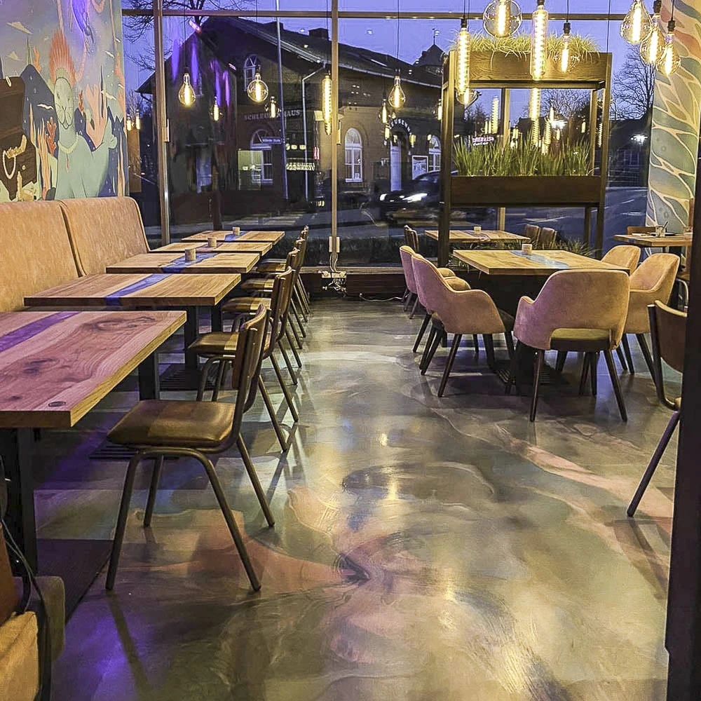 Veredelter Fußboden im Innenbereich eines Restaurants mit vielen Tischen und Sitzgelegenheiten.