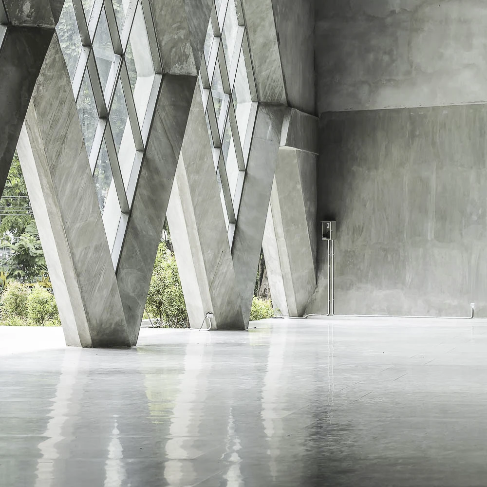 Eine von Resintech veredelte Fassade, die aus Beton und großen, rautenförmigen Fenstern gefertigt ist.